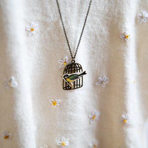 green and yellow bird and bird cage necklace